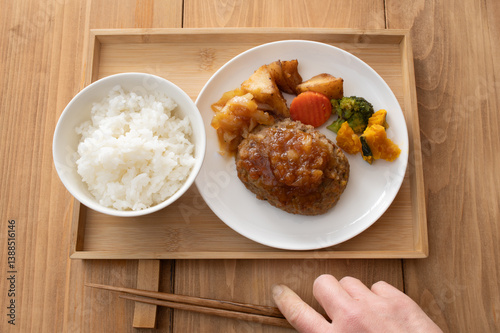 ご飯と玉ねぎソースのハンバーグに野菜のソテーが添えられたプレート