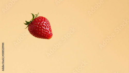 Single luscious strawberry against plain backdrop evokes summer freshness