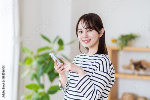Obraz na płótnie スマホを操作する若い女性。
