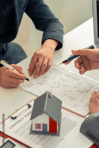 Photography A real estate agent discusses the terms of a home purchase contract and asks the client to sign a document to sign a real estate contract to seek advice on the home he will buy to start a family