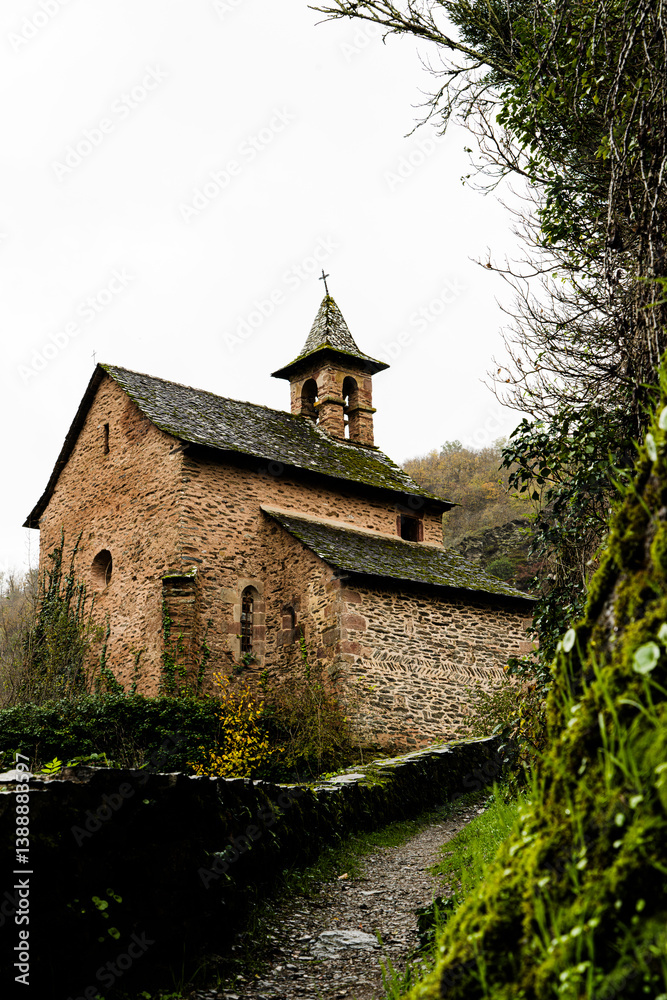 Fototapeta premium Historic Rural Church: Stone Building with Bell Tower Surrounded by Nature