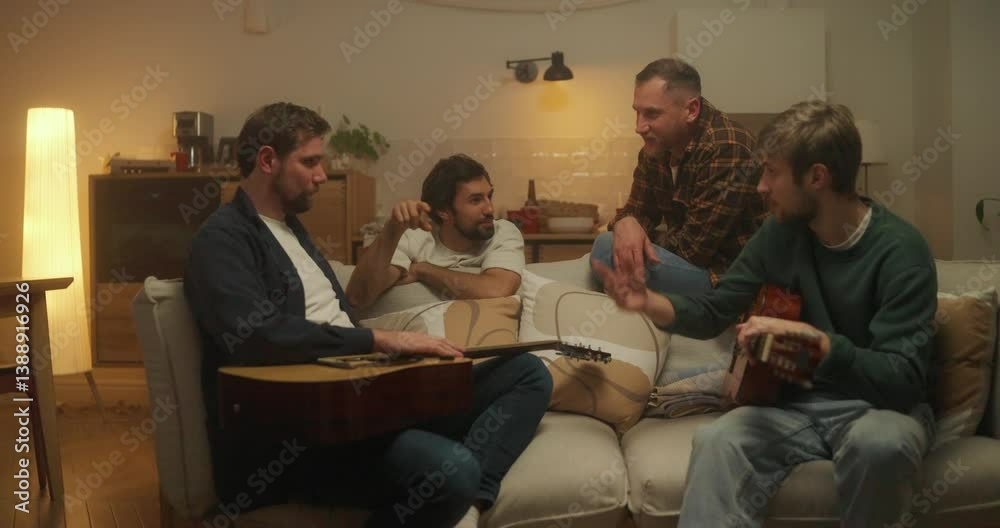Several friends chat while sitting on the sofa and with guitars in their hands during a bachelor party at home in the evening Several friends chat while sitting on the sofa and with guitars in their hands during a bachelor party at home in the evening