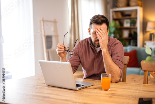Businessman office working holding sore head pain from desk working and sitting all day using laptop computer or notebook suffering headache sick worker overworking concept