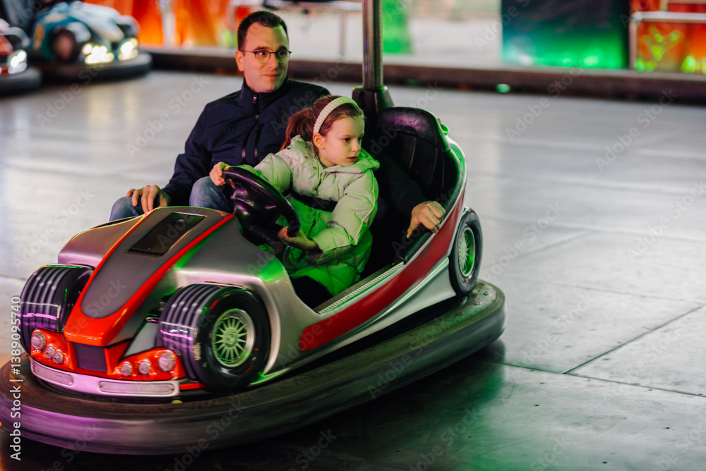 Father and daughter enjoying bumper cars at amusement park Father and daughter enjoying bumper cars at amusement park