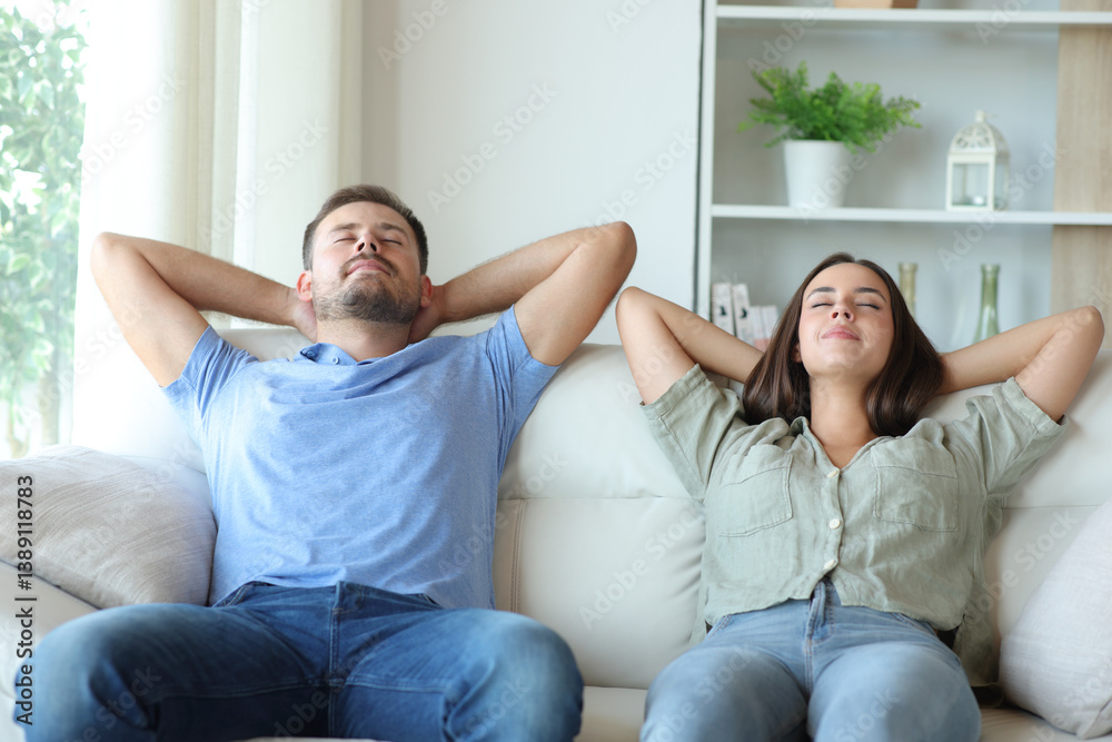 Happy couple at home relaxing and resting on a couch Happy couple at home relaxing and resting on a couch