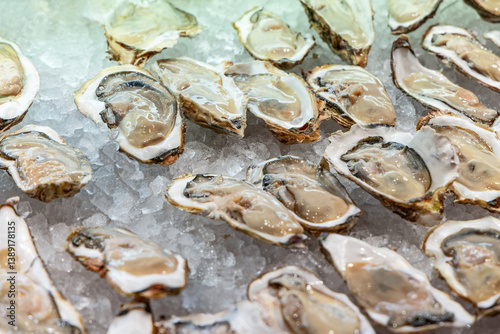 Display of raw oysters on the half shell is arranged on ice at a Tokyo seafood market keeping them chilled and fresh while highlighting their plump texture and natural juices