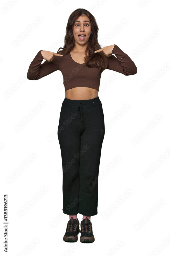 Fototapeta premium Middle Eastern woman, full body studio surprised pointing with finger, smiling broadly.