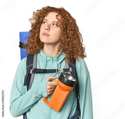 Young Caucasian redhead turning on headlamp for hiking