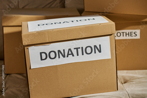 Obraz na płótnie Donation boxes in living room. Packed cardboard boxes full of clothes and toys on couch. Concept of charity, social care and volunteering w salonie