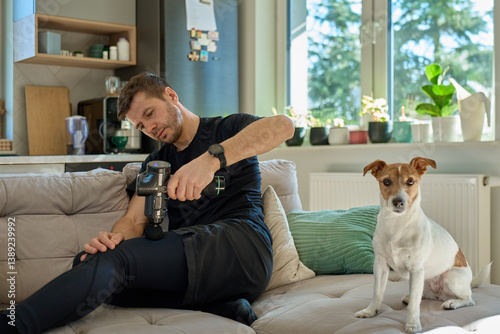 Obraz na płótnie Close-up of man recovery muscle after training, massaging legs with deep tissue massage gun. Sportsman using percussion device for tension and relaxation w salonie