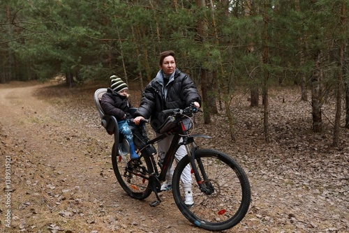 Obraz na płótnie Father biking with child in a forest, enjoying a peaceful afternoon in nature during autumn w salonie