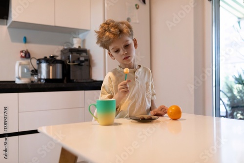 Obraz na płótnie Child engaging in playful activity with colorful items in a bright kitchen during morning hours w salonie