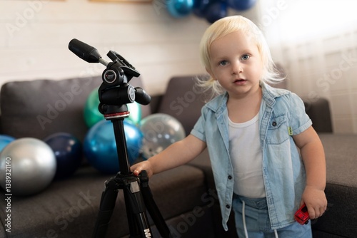Obraz na płótnie Child explores a tripod in a colorful indoor setting filled with balloons during a festive celebration w salonie