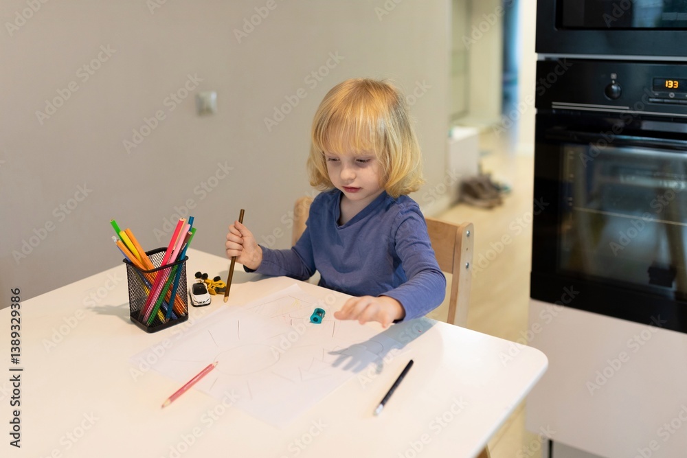 Child engages in creative drawing at kitchen table during afternoon