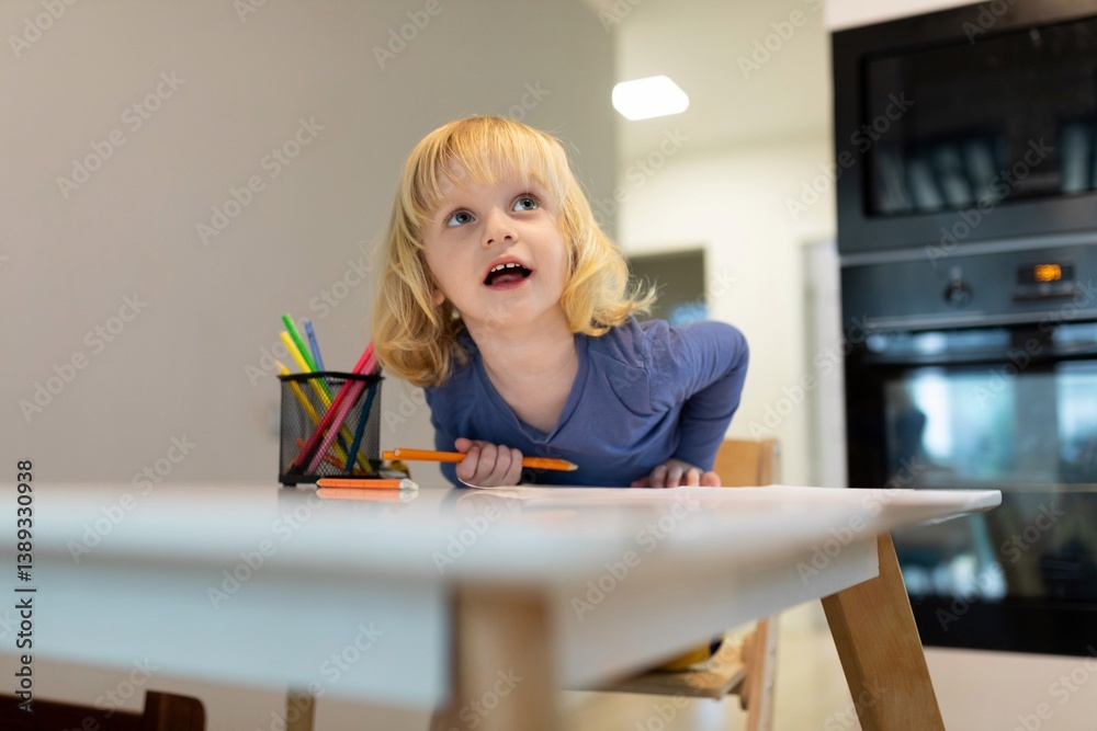 Young child engaged in creative drawing activity at home during midday
