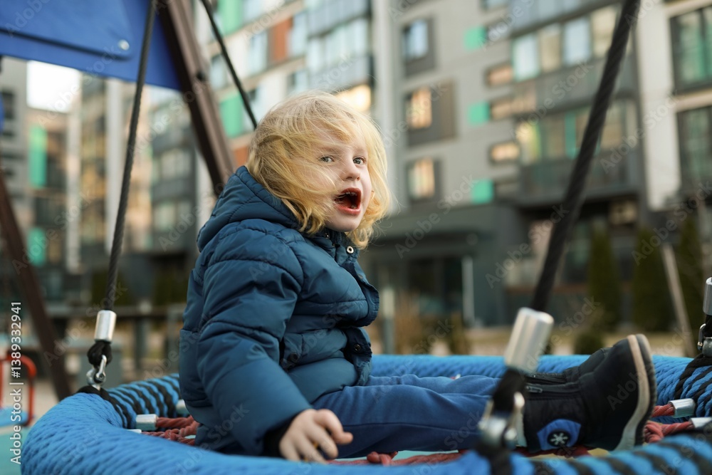 Child joyfully playing on a swing at a modern urban playground in the early afternoon
