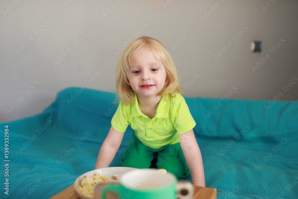 Child enjoying snack on couch during sunny afternoon at home