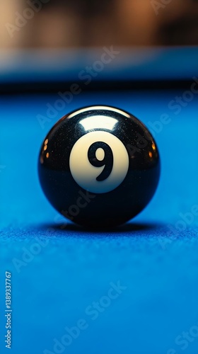 Close-up of a 9-ball on a blue pool table, showcasing the glossy surface and details of the billiard ball, perfect for sports, games, or leisure themes.