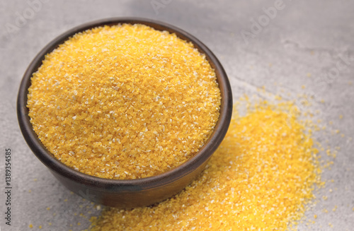 Raw cornmeal in a bowl on a gray tiled table