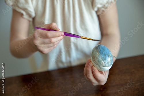 Obraz na płótnie Close-up of a child's hand holding a paintbrush and an easter egg w salonie