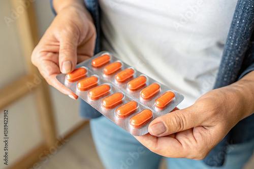 Obraz na płótnie holding a blister pack of orange pills w salonie