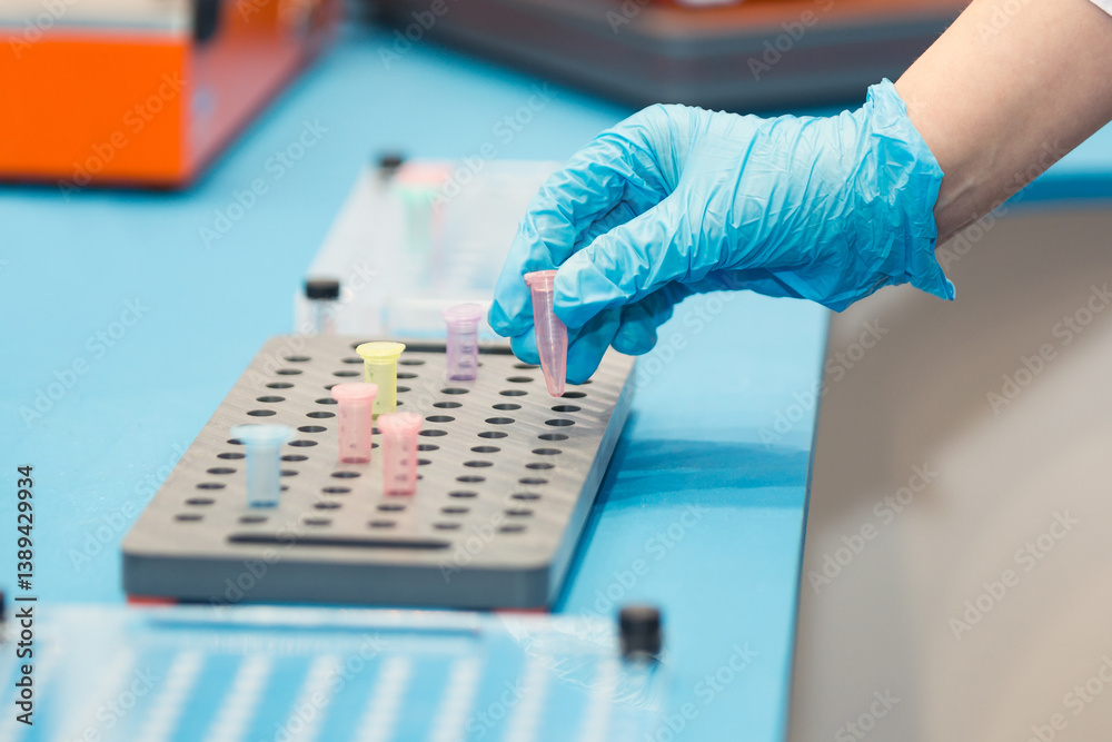 Scientist handling a test tube in a laboratory with colorful equipment in the background