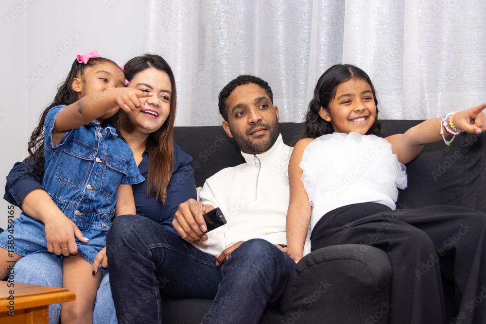 Family watching tv together and pointing at something interesting Family watching tv together and pointing at something interesting