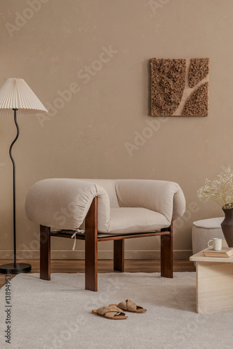 Cozy reading corner with a sculptural armchair, floor lamp, and wall art in earthy neutrals...
