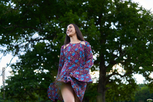Obraz na płótnie Smiling woman in floral dress walking through a meadow......... w salonie
