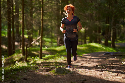Woman jogging in forest trail.........