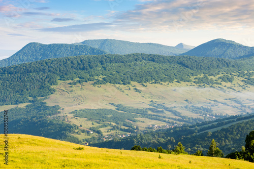Obraz na płótnie mountainous countryside of ukraine in summer. grassy pasture on the rolling hill in morning light. scenic rural landscape of transcarpathia. alpine farmland w salonie