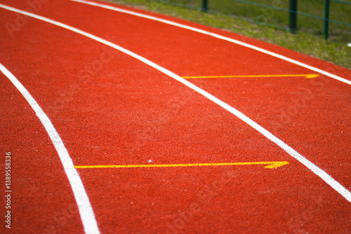 Obraz na płótnie White lane markings on a red running track at an athletics stadium. The textured rubber surface and clear lines indicate starting positions. Shot in daylight, outdoor setting.
w salonie