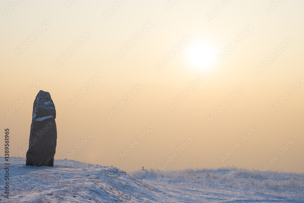 Stone stele on a snowy mountain slope. Fragment of the memorial complex on Mount Samokhval, dedicated to those who died defending the Fatherland. Abakan, Republic of Khakassia, Siberia, Russia.