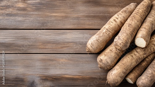 Fresh horseradish roots piled on a rustic wooden table, showcasing their natural texture and color