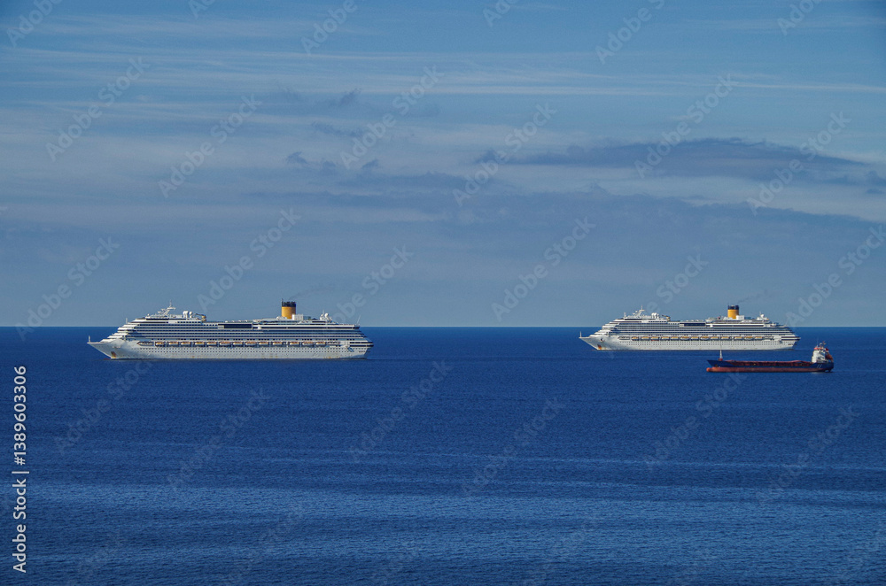 Mega family cruiseship cruise ship liner Favolosa and Fortuna anchored offshore of Civitavecchia Rome, Italy before reactived after Covid pandemic with other vessels in port and coastline