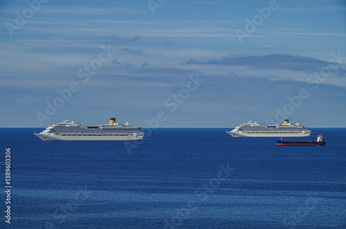 Obraz na płótnie Mega family cruiseship cruise ship liner Favolosa and Fortuna anchored offshore of Civitavecchia Rome, Italy before reactived after Covid pandemic with other vessels in port and coastline w salonie