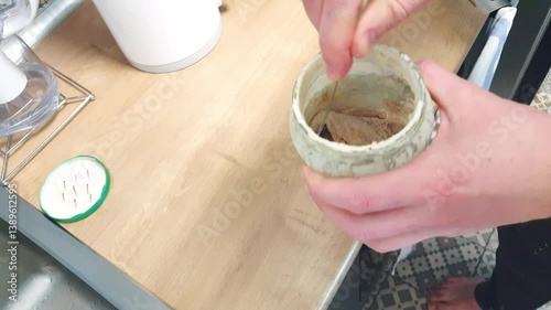 Person prepares fermented sourdough for further baking. Food
