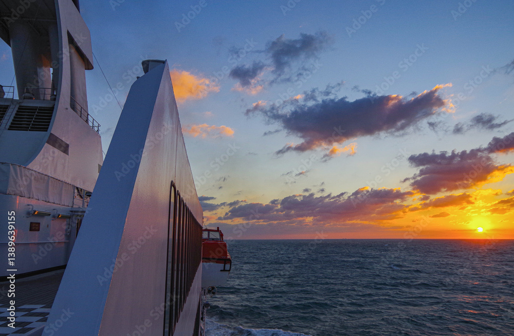 Beautiful breathtaking sunset blue hour twilight panorama at sea with dramatic sky seen from outdoor deck of classic cruiseship cruise ship liner sailing on ocean
