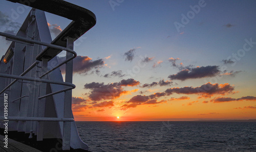 Beautiful breathtaking sunset blue hour twilight panorama at sea with dramatic sky seen from outdoor deck of classic cruiseship cruise ship liner sailing on ocean