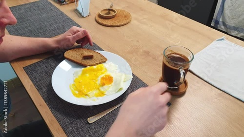 Man having a fried eggs for the breakfast. Food