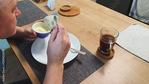 Man having a yogurt for breakfast. Food