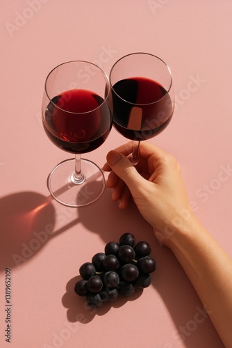 Enjoying Red Wine With Fresh Grapes on a Pink Background During a Cozy Afternoon