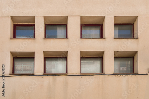 set of eight square windows forming a pattern on a light brown wall