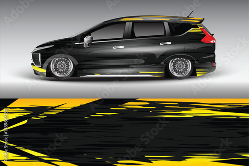 Sleek black car with yellow graphic design parked on a smooth surface, showcasing modern styling