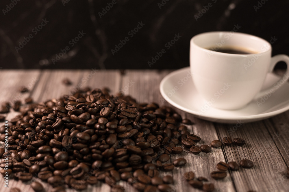 Fototapeta premium Morning coffee. Roasted coffee beans on a dark background. Cup of coffee