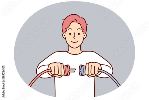 Man holding two cords with high voltage wish to connect wires to start electrical equipment
