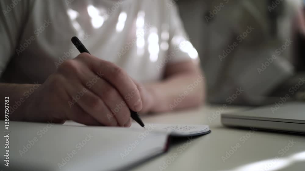 Man’s Hand Holding a Pen While Writing on a Notebook. Journaling his thoughts into notebook, because he has some sort of depression Man’s Hand Holding a Pen While Writing on a Notebook. Journaling his thoughts into notebook, because he has some sort of depression