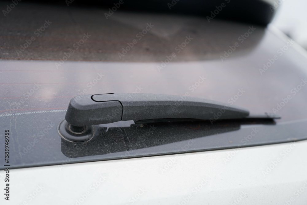 windshield wipers of a dirty white car covered with a layer of dust, a closeup of a part of the vehicle, nobody..