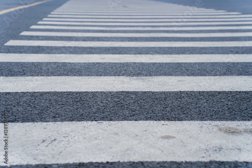 Obraz na płótnie Empty crosswalk on a city street with striped white lines, indicating pedestrian crossing area. Concept of urban infrastructure, pedestrian safety, and road design. High quality photo w salonie