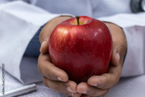 Doctor holding a red apple close-up - Health and nutrition concept.